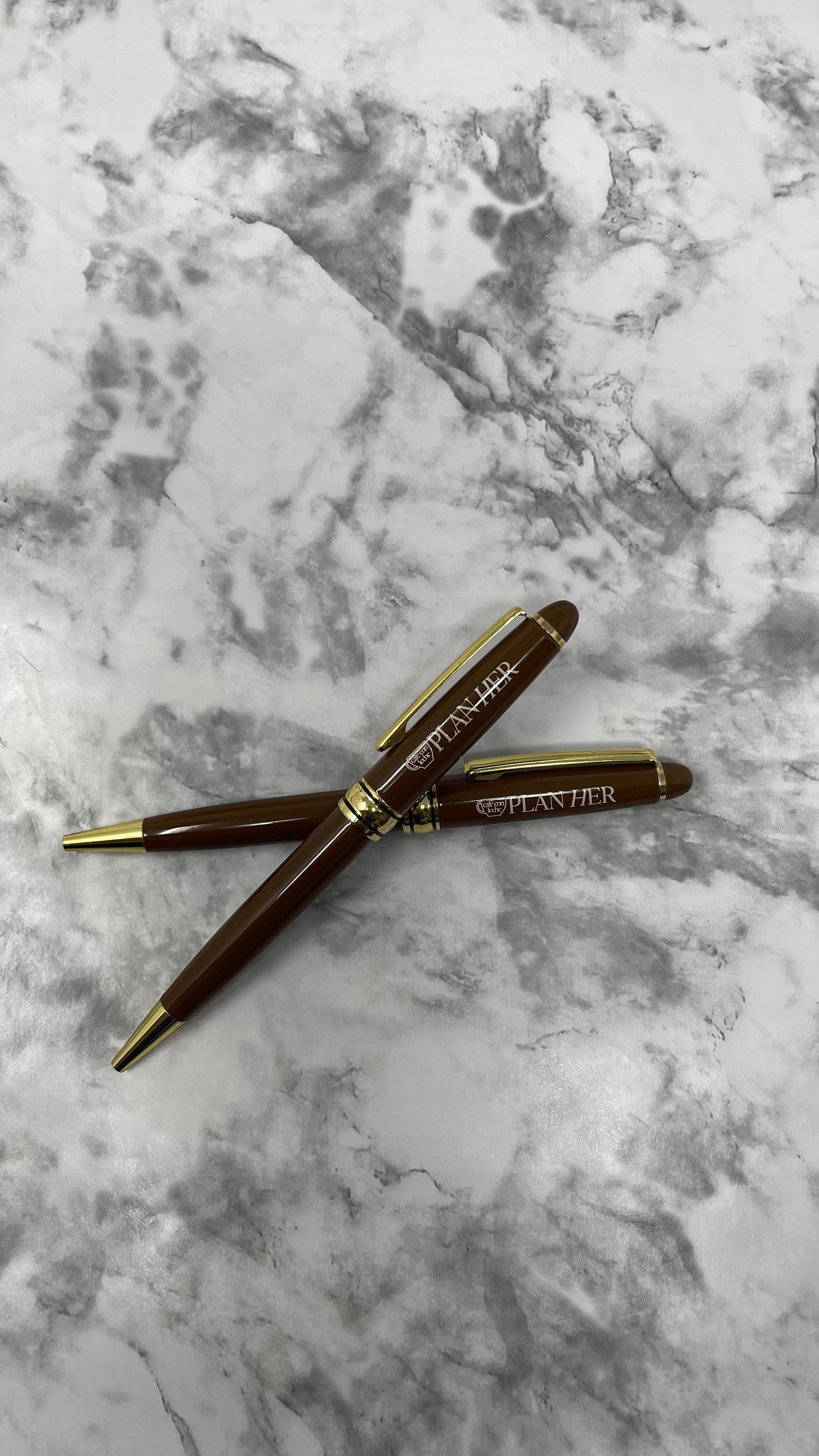 This stylish blue ink pen features a brown barrel with a gold-colored metal tip, making it the perfect writing companion. With a 1.0mm tip, it provides precise, clear lines that won't smudge or bleed. The pen also features the logo, giving it a unique, eye-catching look. Whether you're writing a letter, taking notes, or just doodling, this pen is sure to make a statement.